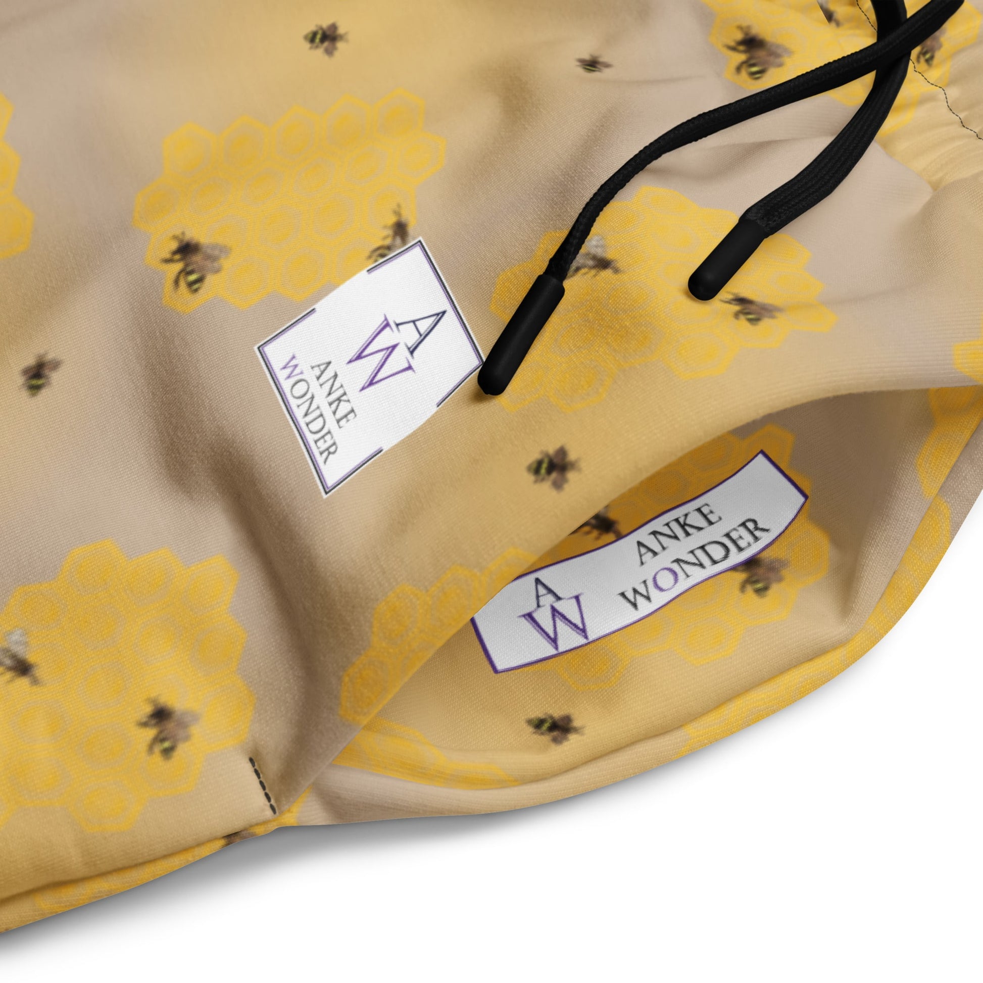 Side close-up of men's joggers showing bee artwork and eco-conscious Anke Wonder Branding.