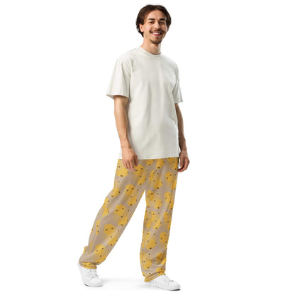 Front left view of man wearing bee-themed joggers featuring yellow beehive pattern from handpainted artwork by Anke Wonder.