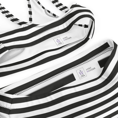 Inside of black and white striped swimsuits with brand label "Anke Wonder" on a white background