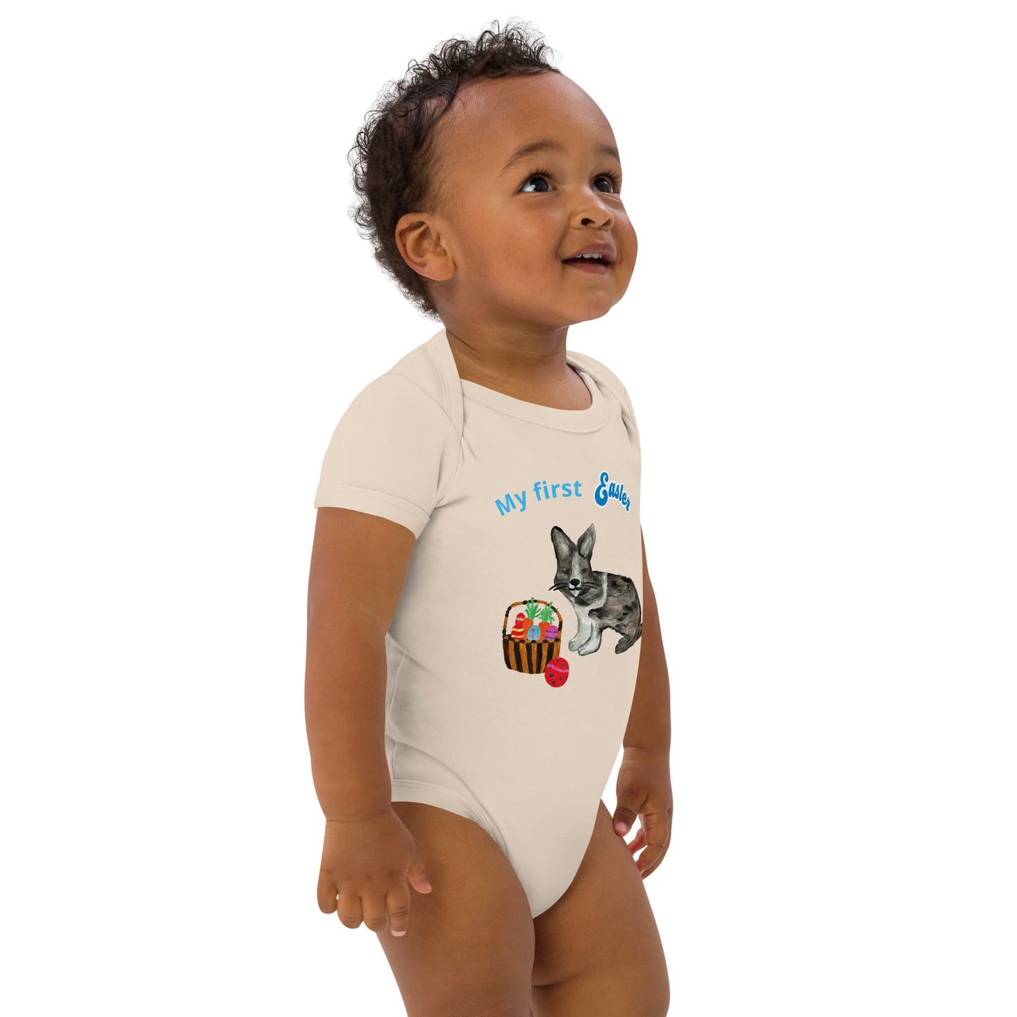 Front right view of a natural color short-sleeve organic cotton baby bodysuit featuring a bunny and Easter basket design, with 'My First Easter' in blue text.