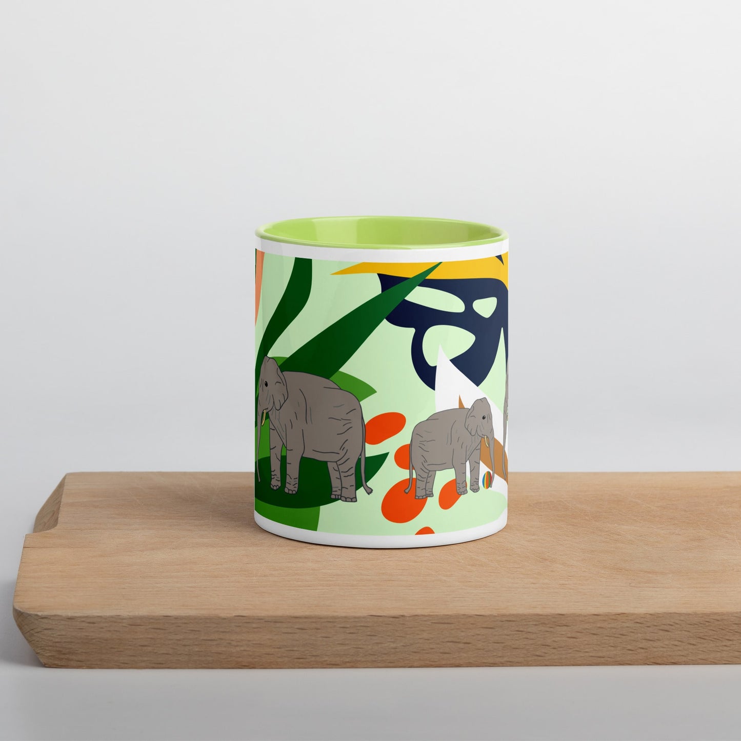 Colorful ceramic mug with green handle and jungle-inspired background featuring a parent and baby elephant – eco-conscious animal design by Anke Wonder.