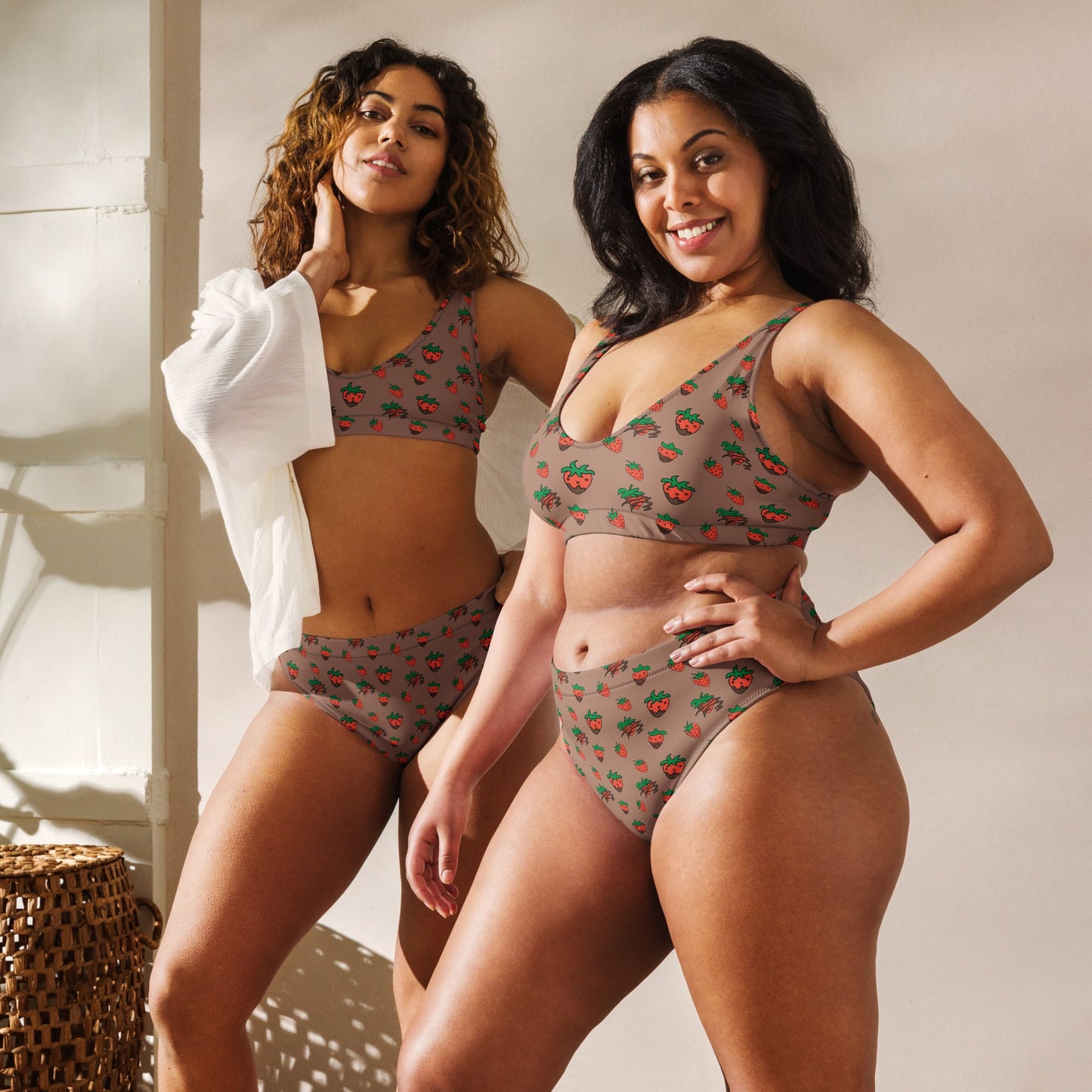 Plus-size woman confidently wearing a recycled high-waisted bikini with fun strawberry print, showcasing inclusive sizing and comfortable fit.