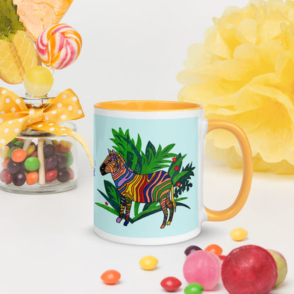 Mug with a colorful zebra design on a light blue background, surrounded by candies and flowers.