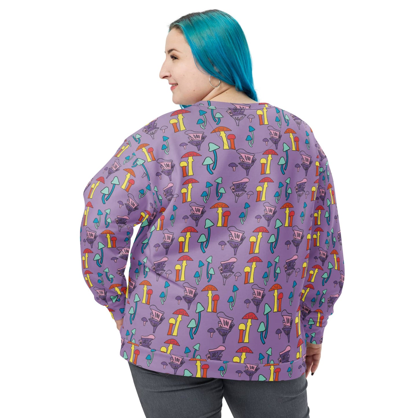 Back view of a woman with blue hair wearing a purple mushroom-print sweatshirt. The vibrant all-over print continues seamlessly on the back, showing the relaxed fit and cozy fleece fabric.