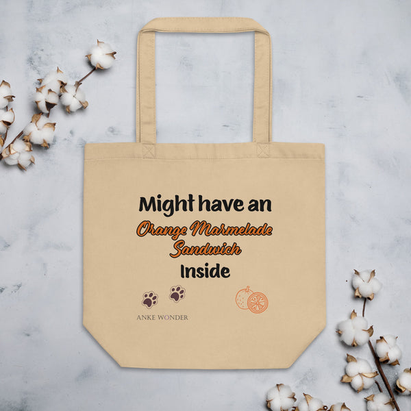 Beige tote bag with "Might have an Orange Marmalade Sandwich inside" text, paw prints, and an orange illustration - perfect for Paddington Bear fans.