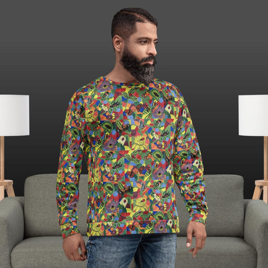 Man wearing a colorful patterned sweatshirt with flowers and butterflies standing in a room with gray furniture and white lamps.