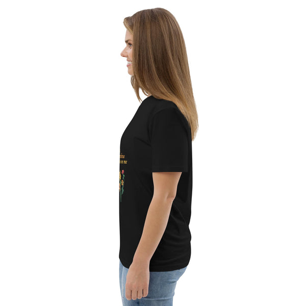 Side view of woman wearing a black t-shirt with a colorful graphic on the front, standing against a white background