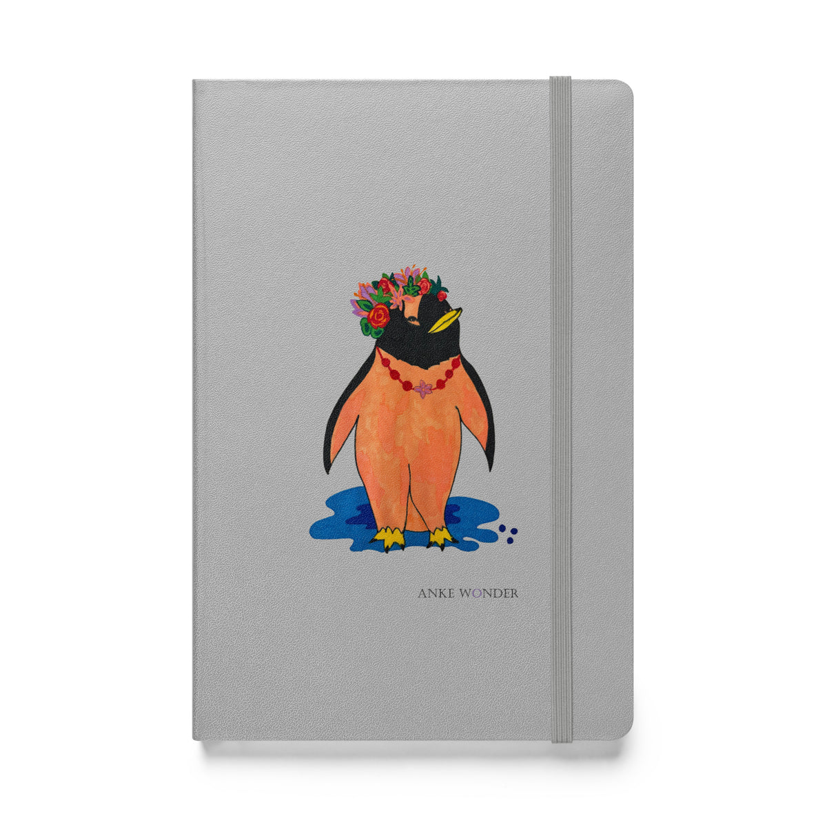 Colorful artistic penguin notebook with a silver-grey hardcover, featuring a stylized orange penguin wearing a vibrant floral crown standing above a blue shadow.