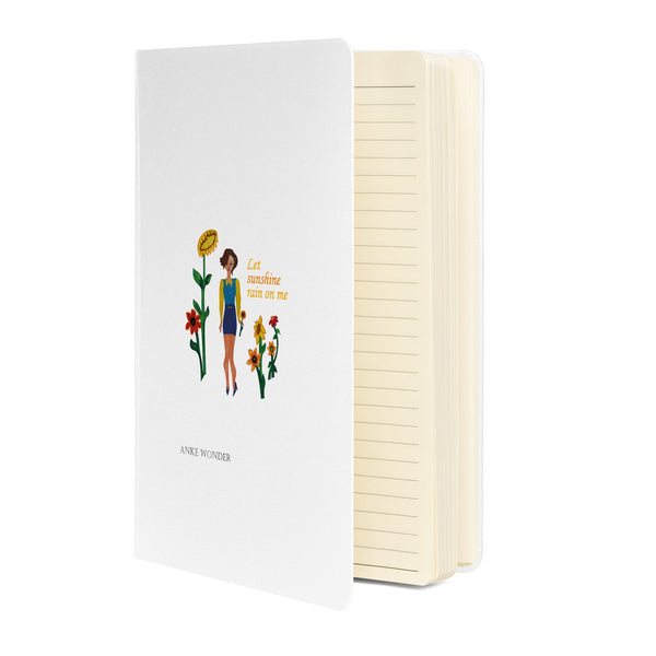 Notebook with illustration of a woman and sunflowers on the cover, white background