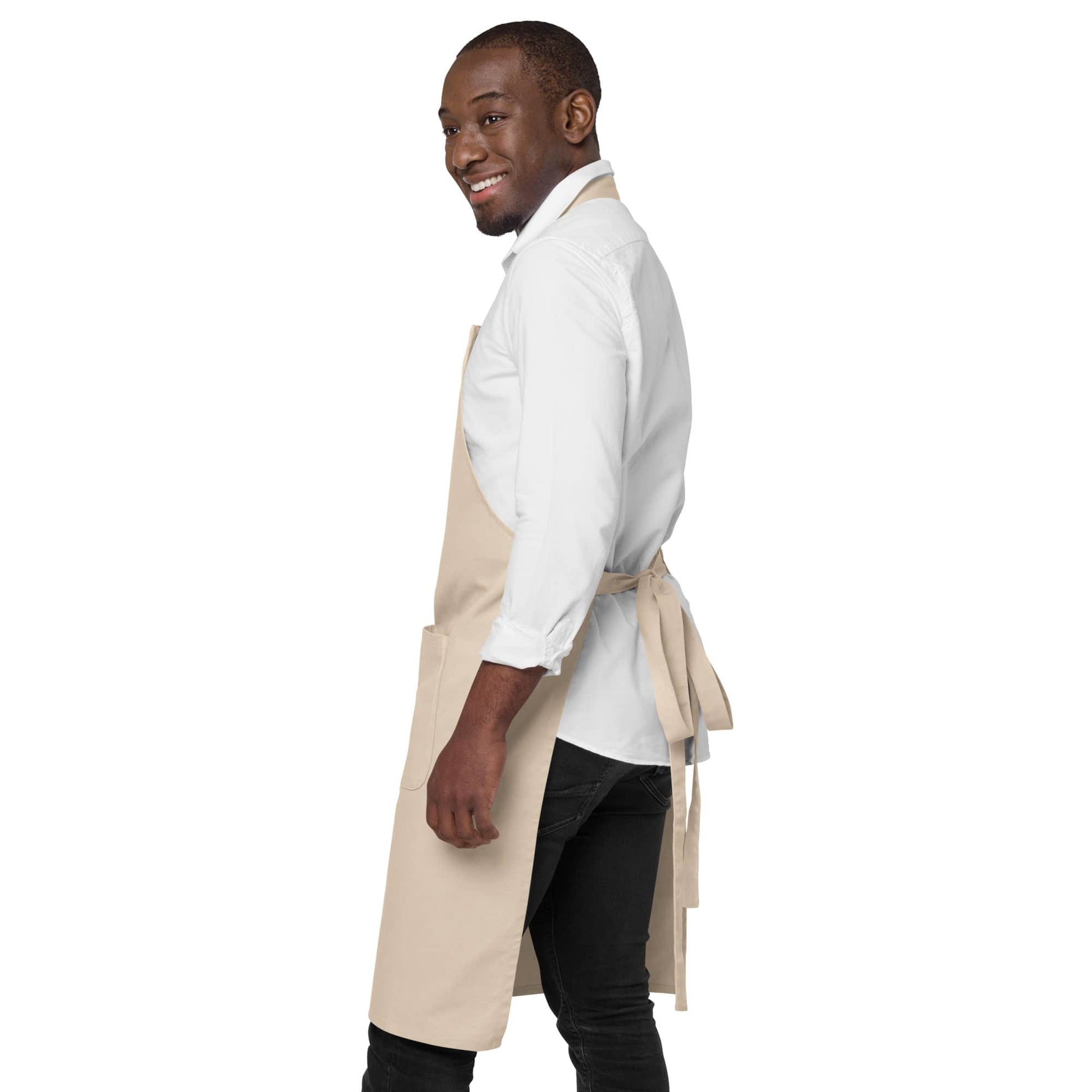 Side view of a man wearing a beige organic cotton apron by Anke Wonder.