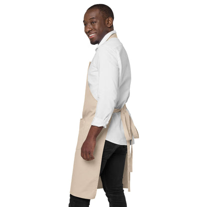 Side view of a man wearing a beige organic cotton apron by Anke Wonder.