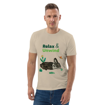 Man wearing beige organic cotton t-shirt with hand-painted black-and-white rabbit, butterfly, and greens. Text reads: Relax & Unwind.