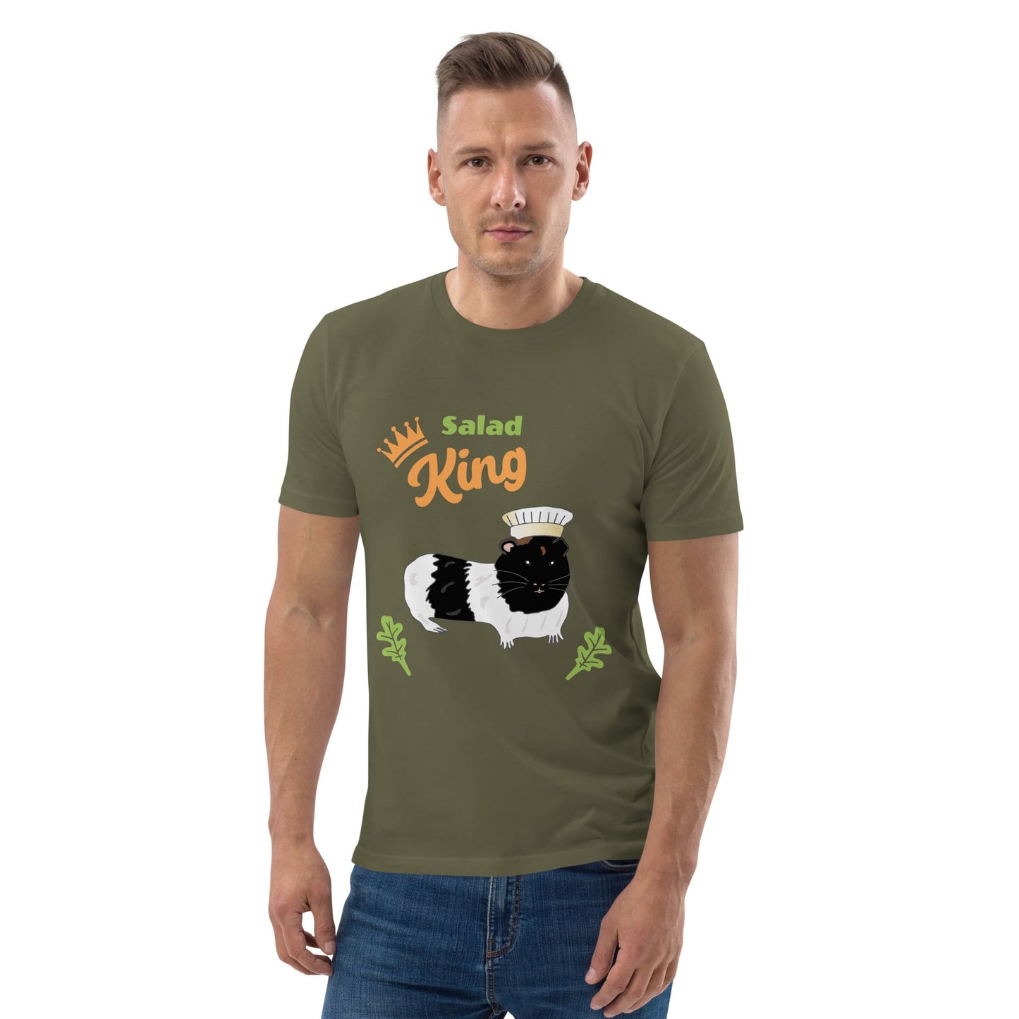 Man wearing an organic cotton t-shirt in khaki with a "Salad King" design featuring a black and white guinea pig in a chef’s hat, surrounded by greens.