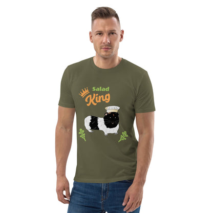 Man wearing an organic cotton t-shirt in khaki with a "Salad King" design featuring a black and white guinea pig in a chef’s hat, surrounded by greens.