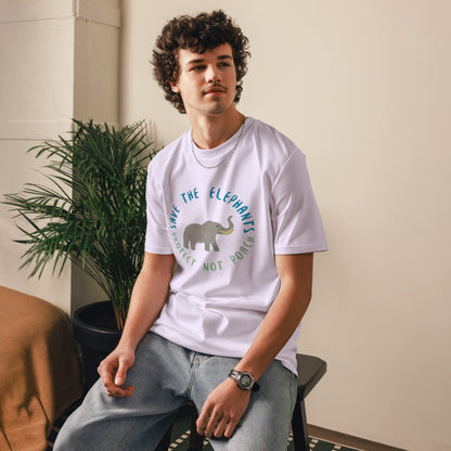 Man sitting while wearing a lavender “Save the Elephants – Protect Not Poach” organic cotton t-shirt; the relaxed posture and minimalist setting highlight the soft, ethical fabric.