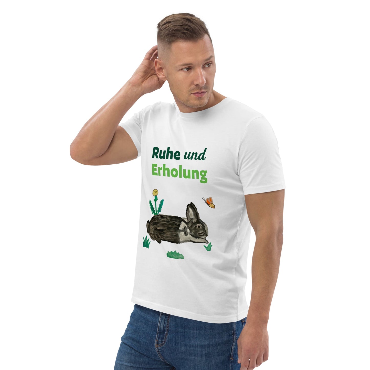 Man wearing white organic cotton t-shirt at right angle, showing "Ruhe & Erholung" text and hand-painted rabbit, butterfly, and foliage design.