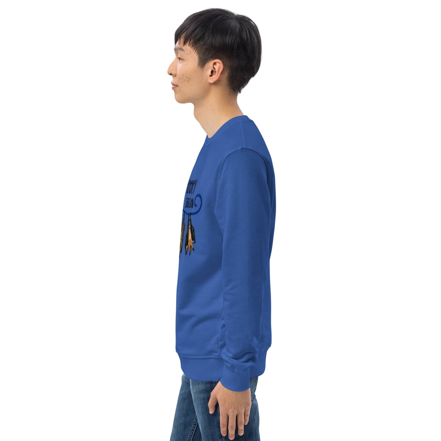 Side view of man wearing a blue sweatshirt with a graphic design on the sleeve against a white background