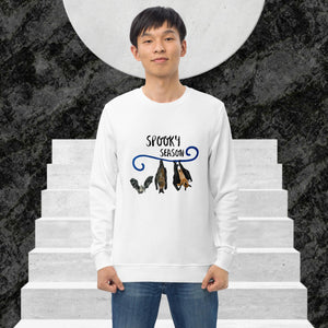 Man wearing a white sweatshirt with 'Spooky Season' design on a staircase background