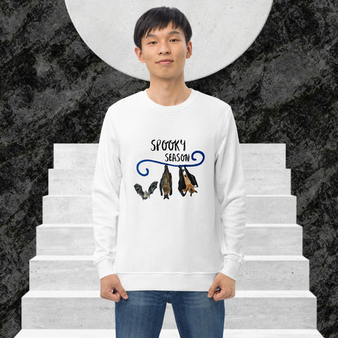 Man wearing a white sweatshirt with 'Spooky Season' design on a staircase background
