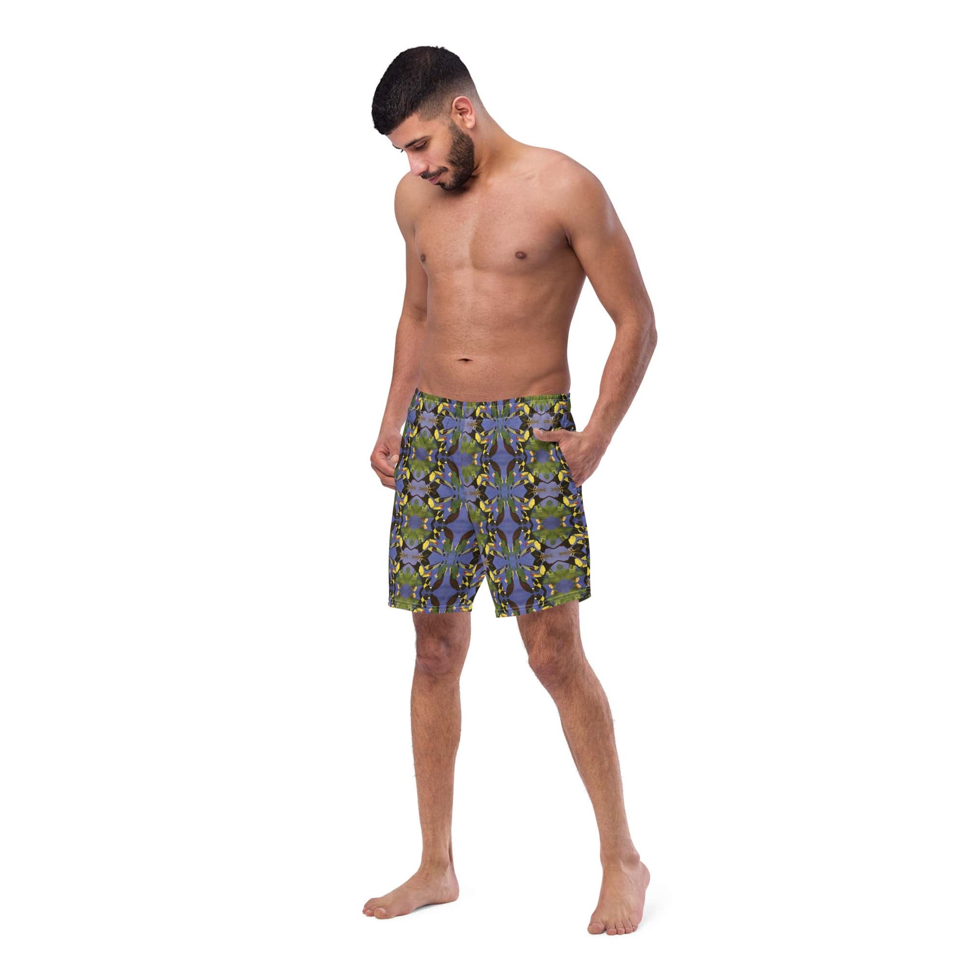 Man wearing tropical bird swim trunks made from recycled polyester, front left view.