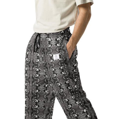 A detailed close-up of the left front side of men's wide-leg joggers, showcasing the black-and-white bird pattern and Anke Wonder's logo.