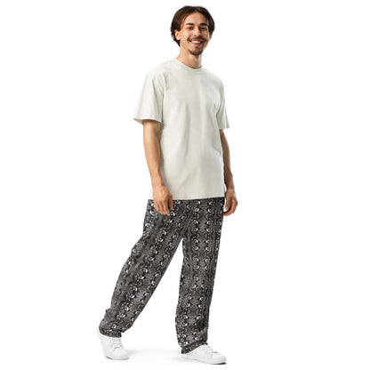 A model in a three-quarter front-left pose, highlighting the wide-leg cut and intricate bird pattern of the joggers.
