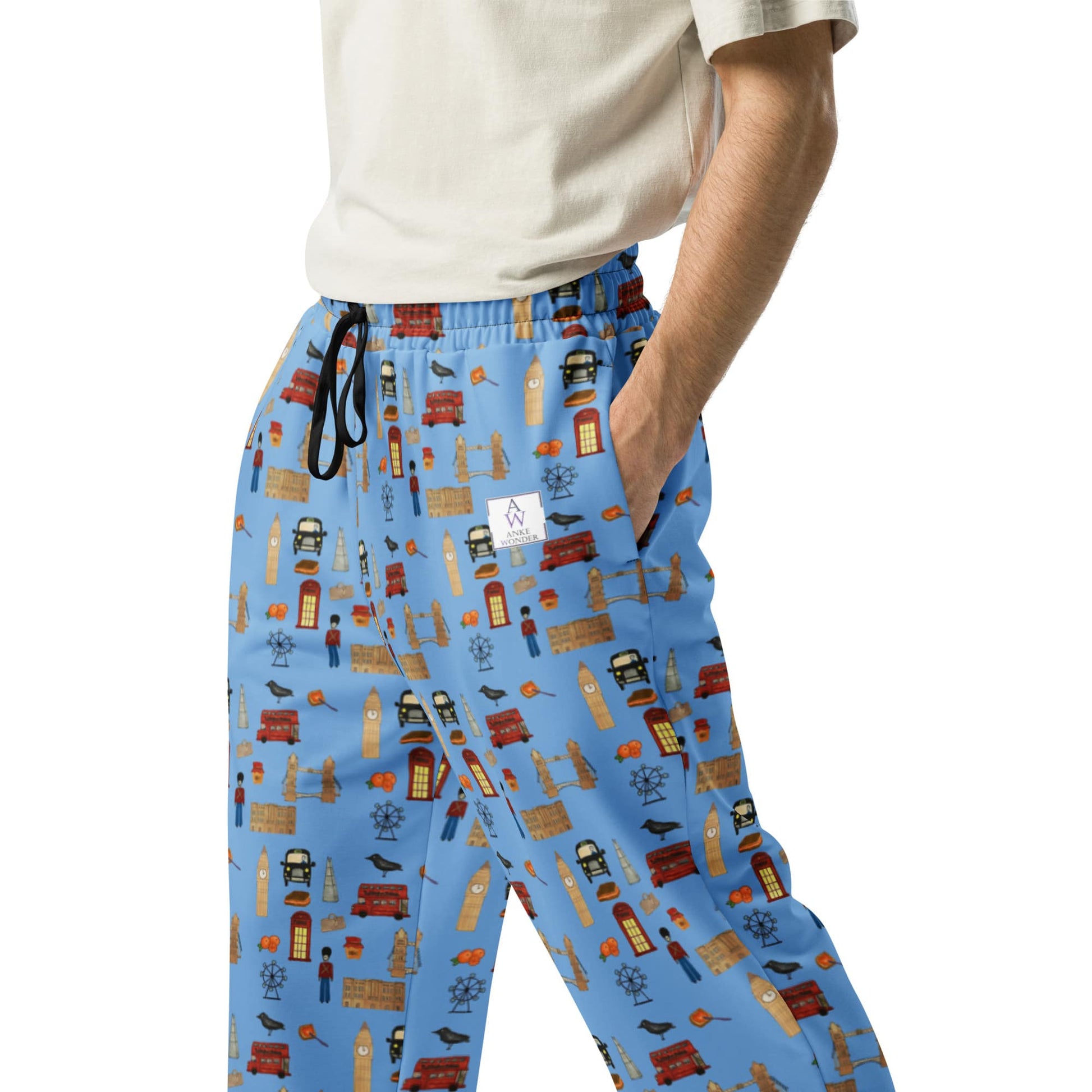 Close-up of men’s joggers with handpainted London-themed print in blue, featuring Tower Bridge, red buses, and phone booths, designed by Anke Wonder.