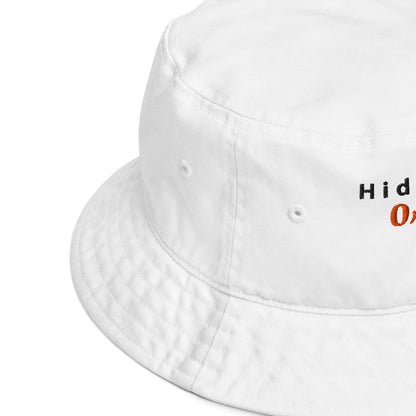 Side view close-up of the white embroidered bucket hat, showcasing fine stitching and quality fabric with a slight curve in the brim.