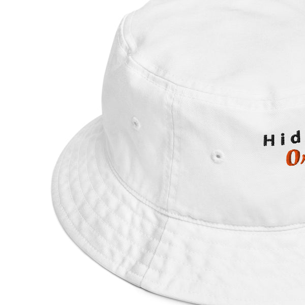 Side view close-up of the white embroidered bucket hat, showcasing fine stitching and quality fabric with a slight curve in the brim.