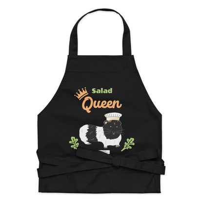 A detailed flat-lay of the black apron, highlighting the adorable guinea pig chef design and playful text 'Salad Queen'.