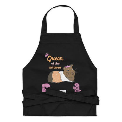 A flat-lay of the black apron detailing the guinea pig illustration and “Queen of the Kitchen” lettering in playful pink.