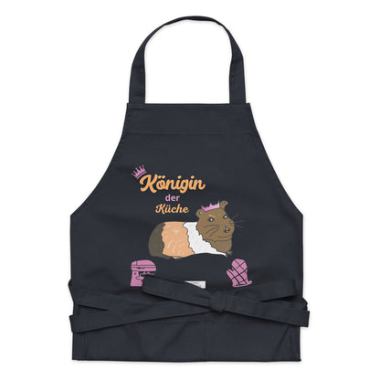 A flat-lay of the navy apron showing the detailed guinea pig design and the clear, stylish “Königin der Küche” lettering.