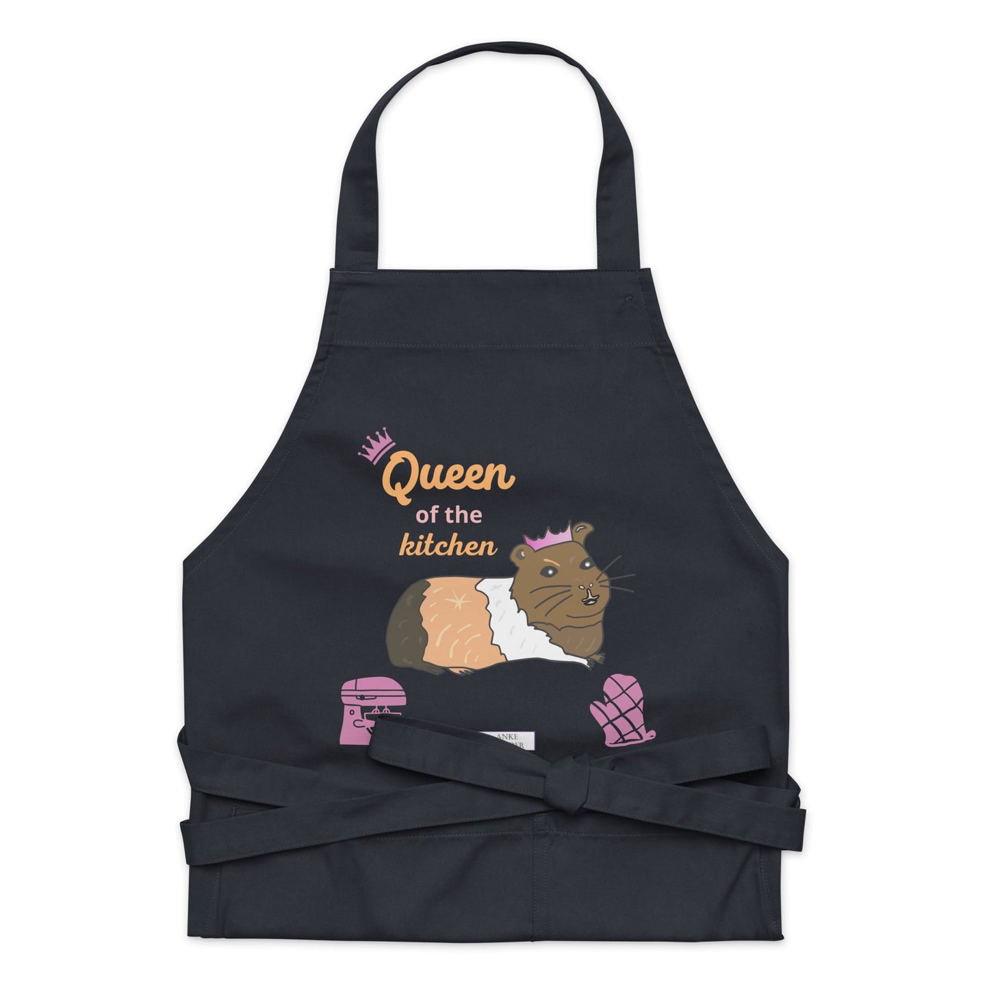 A flat-lay of the navy apron displaying the guinea pig in a pink crown and bold “Queen of the Kitchen” text.