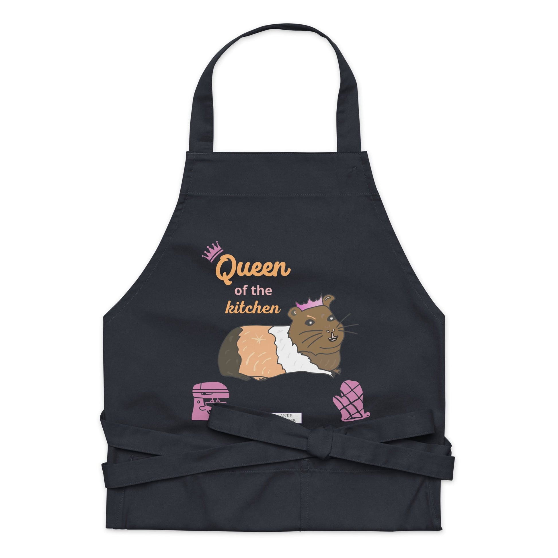A flat-lay of the navy apron displaying the guinea pig in a pink crown and bold “Queen of the Kitchen” text.