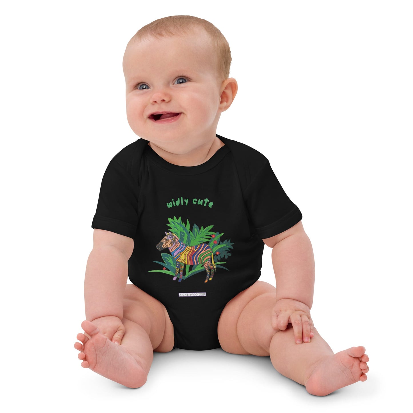 Baby girl wearing a black onesie with a zebra design and the words 'widly cute' by Anke Wonder.