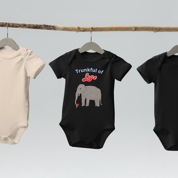 Black organic cotton bodysuit with a cute elephant and red flower in trunk , hanging on wooden hangers.
