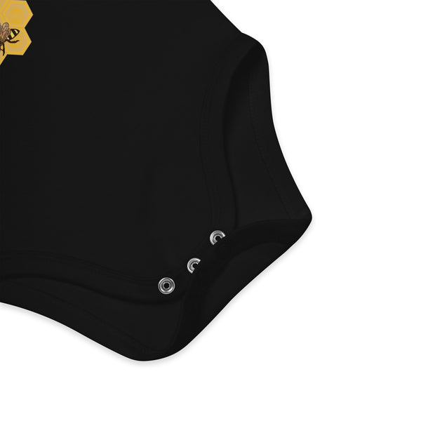 Zoomed-in view of the nickel-free snap fasteners on the black organic cotton baby bodysuit for quick diaper changes.