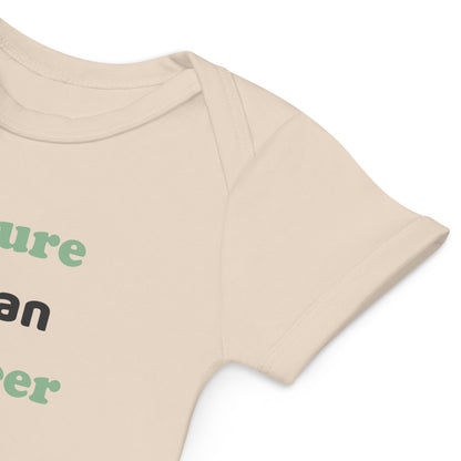 A close-up view of the sleeve of a natural-colored organic cotton baby bodysuit, displaying its raw, eco-friendly fabric and fine craftsmanship.