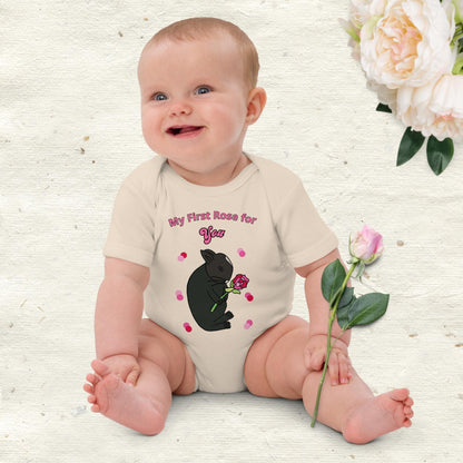Natural organic cotton baby girl bodysuit with bunny holding a pink rose and the text “My First Rose for You.” worn by a baby girl.