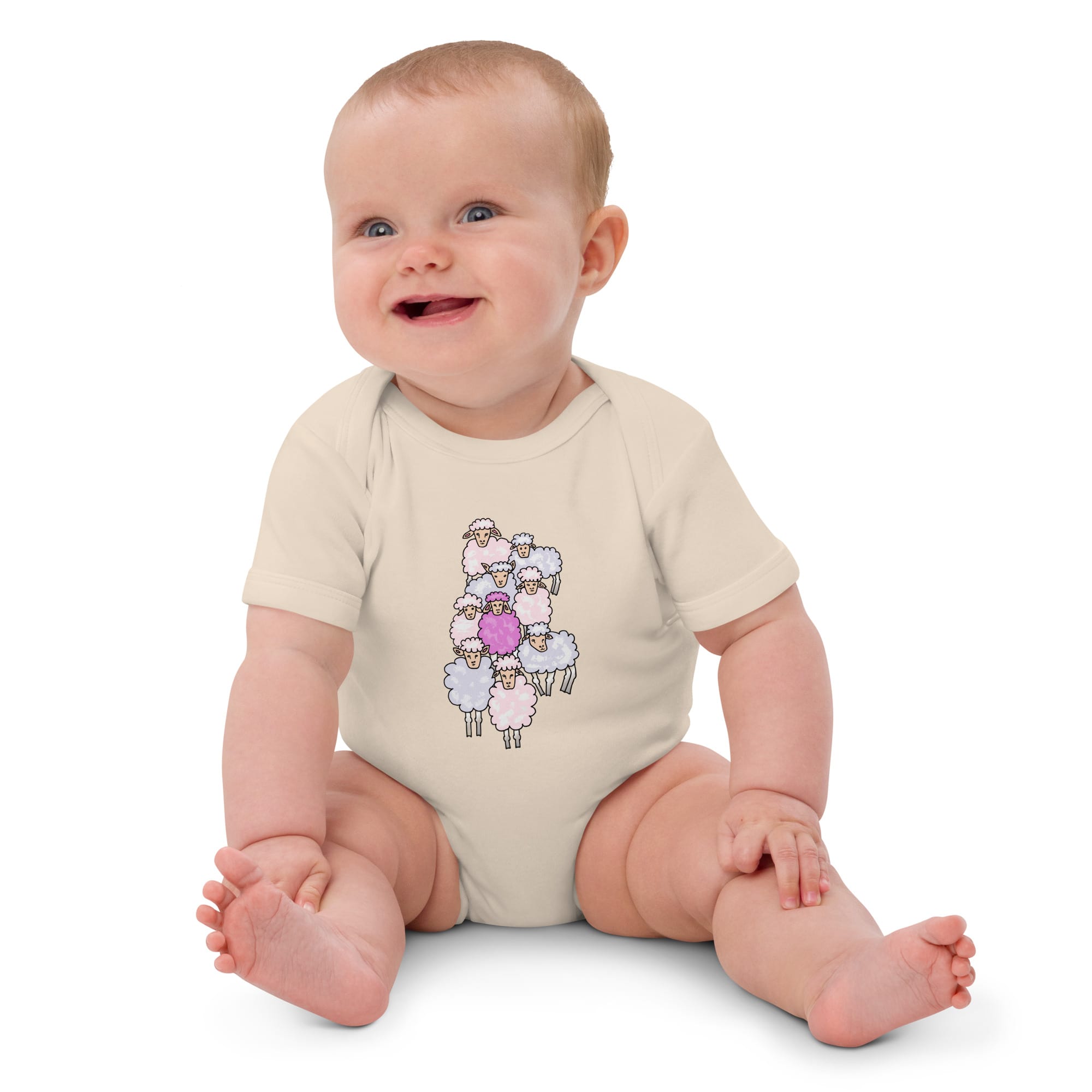 Baby girl sitting while wearing an organic cotton pink sheep bodysuit, designed by Anke Wonder.