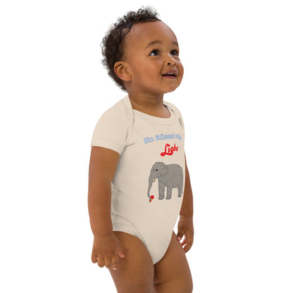 Smiling baby boy right front wearing a natural-colored bodysuit with elephant and red flower.