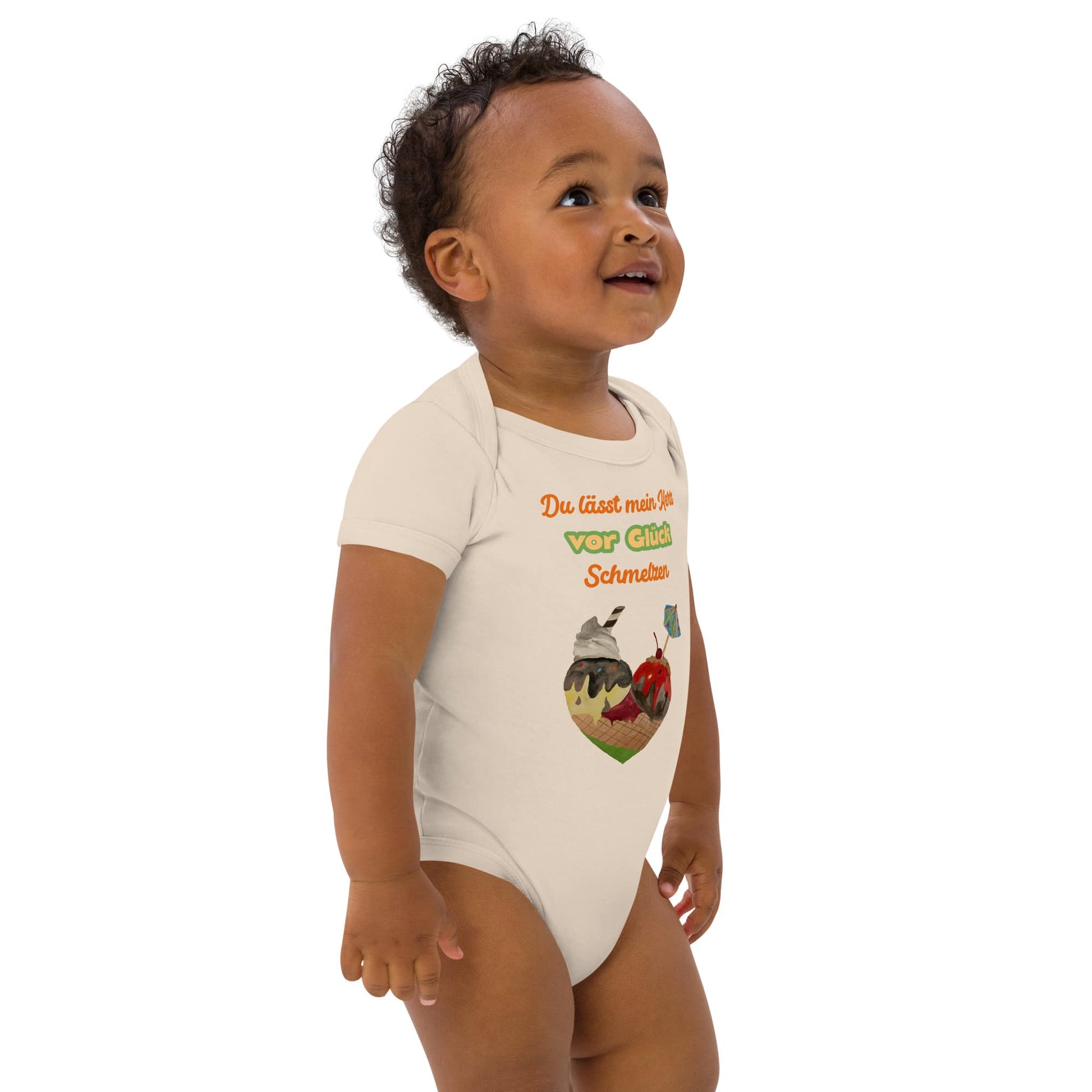 Front right of baby boy wearing natural organic bodysuit with colorful German quote 'Du lässt mein Herz vor Glück schmelzen' and ice cream cone heart.