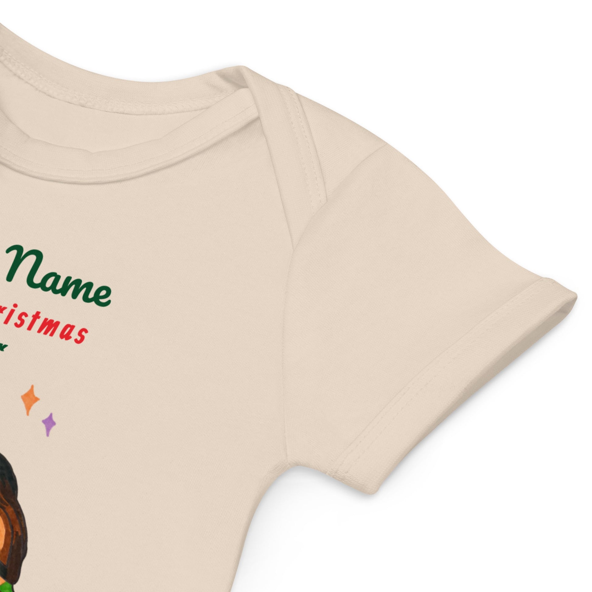 Close-up of beige baby onesie with Christmas-themed design on a white background