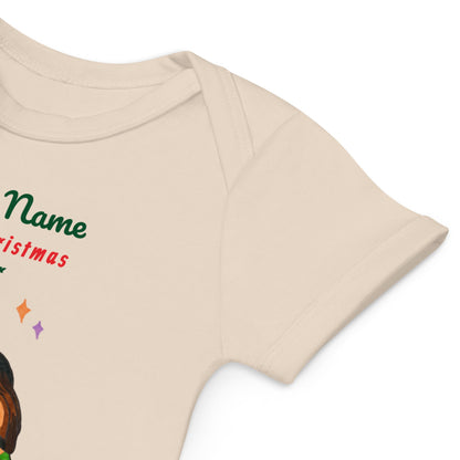 Close-up of beige baby onesie with Christmas-themed design on a white background