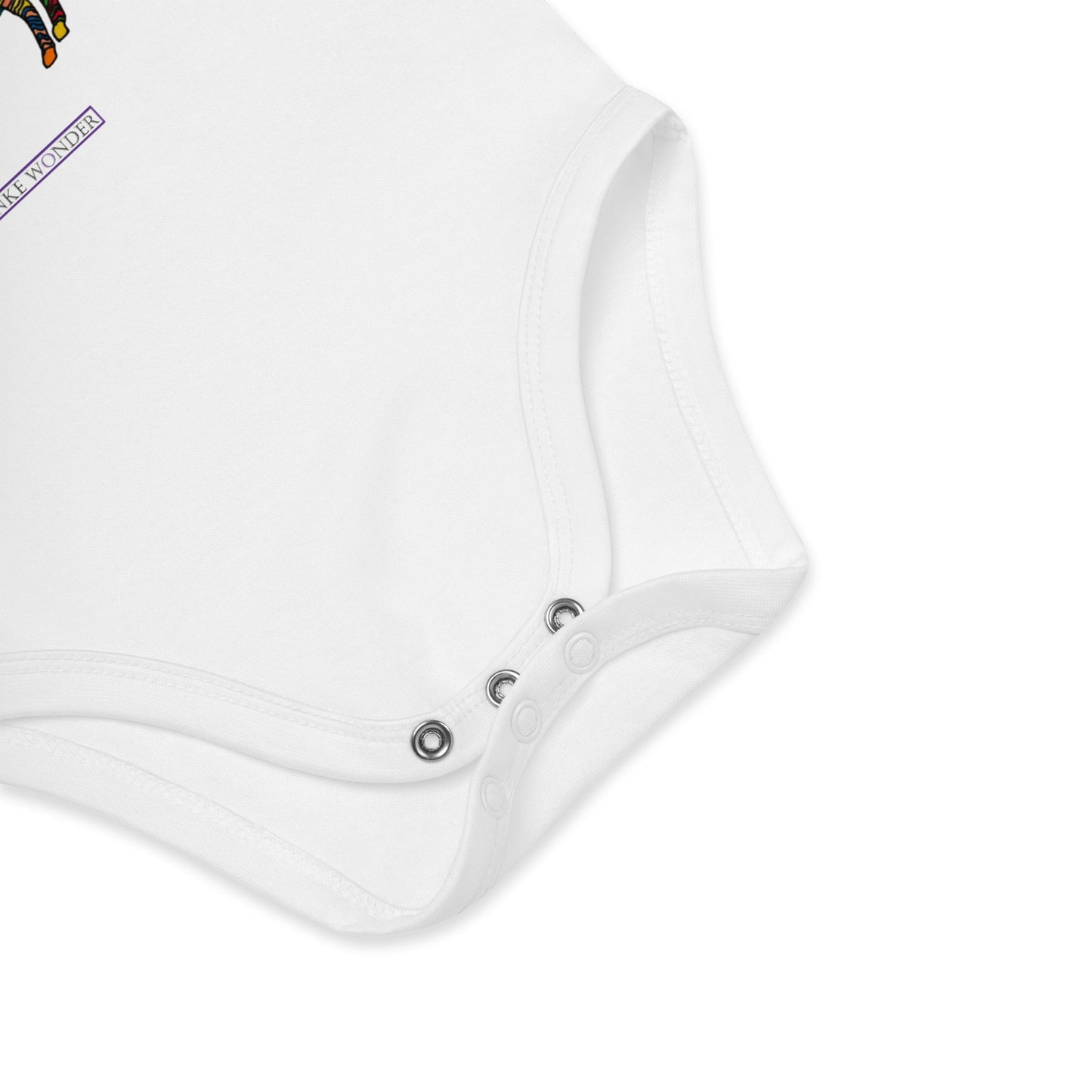 Close-up of a white baby onesie with brand logo 'Anke Wonder' on a white background