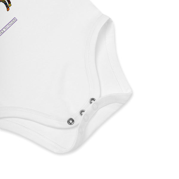 Close-up of a white baby onesie with brand logo 'Anke Wonder' on a white background