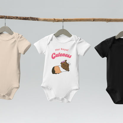 Organic cotton baby bodysuit in white, hanging on a wooden hanger, showcasing a cute guinea pig design with crown.