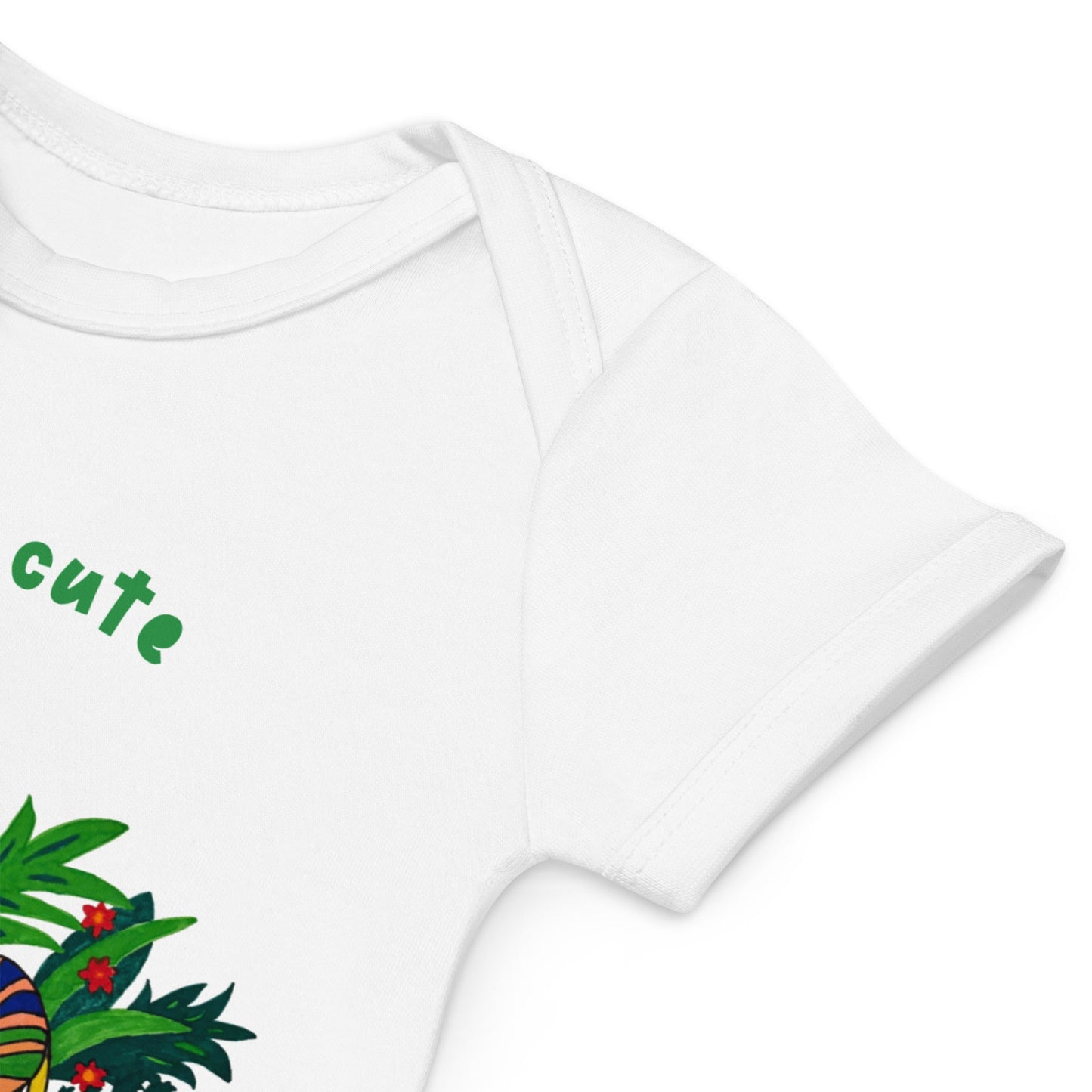 Sleeve detail of white baby bodysuite with colorful design and 'cute' text on a white background