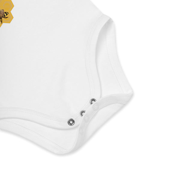 Zoomed-in view of the nickel-free snap fasteners on the white organic cotton baby bodysuit for quick diaper changes.