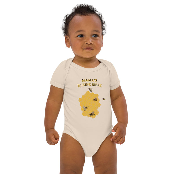 Young boy wearing a natural organic baby bodysuit with a german honeybee design by Anke Wonder, smiling at the camera.